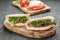 Rustic sandwiches with ham arugula and tomatoes in