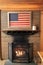 Rustic setting, with framed flag set over roaring fireplace