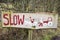 Rustic slow sign on wooden post with illustrations