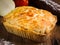 Rustic Small Chicken Pie on Wooden background and a rolling pin