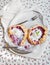 Rustic small galeta pies with fresh berries and vanilla ice-cream on silver dish over a piece of white linen fabric and floral pa