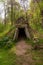 Rustic solitary hut made of wooden timbers and green sod exterior.