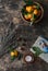 Rustic still life with fresh mandarins, dried herbs, books, candles, and a free space for text on wooden background, top view.