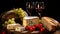 Rustic still life with wine, bread, cheese, tomatoes, and grapes on a wooden table