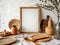 Rustic still life with a wooden frame, vase, cutting board, and other kitchenware on a table