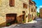 Rustic stone houses decorated with colorful flowers, Monticchiello, Tuscany, Italy