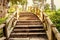 Rustic stone stairway with wooden handrails ascending through the forest to the sky. overcoming concept