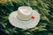 Rustic straw hat and red poppy on barley ears in evening field close up. Wildflowers and farm hat in summer countryside.