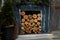 Rustic style Christmas festive decorations, fireplace with firewood, fresh spruce thuja, fir branches, warm garland lights boke.