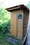A rustic summer toilet is a light homemade wooden building in the garden