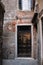 Rustic townhouse door in one of the dead-end side streets in the old town, Venice, Italy