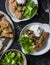 Rustic vegetarian wild mushrooms and potatoes whole grain pie with greek yogurt and green salad on a dark background, top view.