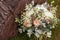 Rustic wedding bouquet with roses and succulents on green grass