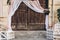 rustic wedding photo zone. wooden barn doors with fabric and white boxes with flowers and candles at stylish wedding photo booth.