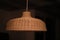 Rustic wicker ceiling light hanging from a rope cord, providing a cozy, intimate atmosphere