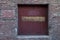 Rustic wood door surrounded by aging brick wall.