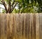 Rustic wood fence with green shade trees