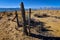 Rustic wood and wire fence in arid valley with distant snowy mountains