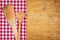 Rustic wooden background with a checkered tablecloth and wooden spoons