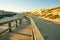 Rustic wooden beach boardwalk through sand dunes, Oso Flaco Lake, CA