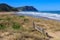 Rustic wooden bench on remote Waihau Beach, New Zealand