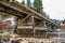 Rustic wooden bridge over a rocky stream with shiny water