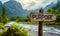 Rustic wooden signpost with the word PURPOSE pointing forward against a backdrop of majestic mountains and river, symbolizing