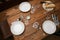 Rustic wooden table half laid with plates, glasses, cutlery and bread for an informal meal with family or friends