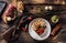 Rustic wooden table with a raw deer venison, delicious homemade dumpling and rosemary. Between the plate full of venison goulash