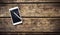 Rustic wooden table with smartphone. View from above