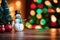 A Rustic Wooden Table With Snowman And A Pine Tree In The Blur Background