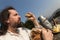 Rustically man with long hair eating bread in the nature