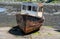 Rusting derelict boat left on a beach