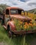 A rusting truck now adorned with a collection of vibrant wild poppies. Abandoned landscape. AI generation