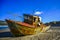 Rusty abandoned ship ashore at low tide