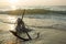 RUSTY ANCHOR WET BEACH SAND AND WHITE SEA WAVE FOAM