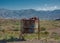 Rusty bin with flowers in mountainous scenery in Mendoza, Argentina