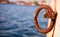 Rusty bollard waits at quay for a boat to be tied. Blur sea for background, closeup, details, banner