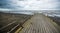 Rusty bridge stretching into the lifeless sea, Caspian sea under blue sky in early September, snag on the beach