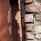 Rusty broken drainpipe on brick wall