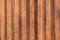 Rusty brown grunge corrugated metal wall with vertical stripes