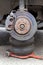 Rusty car wheel hub with brake disc at tire shop. Car without a wheel lifted on the pneumatic jack while replacing