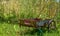 Rusty cart on the field of golden wheat under sunlight harvest season background