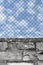 Rusty chain link fence, white grey brick wall texture background, blue summer sky clouds, vertical old weathered security pattern