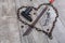 Rusty chain in the shape of heart and machete on a wooden background. Top view from an angle