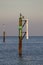 Rusty channel marker in sea with calm water and sky