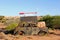 Rusty classic car decays signboard opal mining, Australian deserts