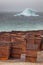 Rusty drums on Arctic coast with iceberg on background