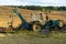 Rusty excavator working in countryside. Weathered excavator digging ground during agricultural works in field on summer