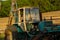 Rusty excavator working in countryside. Weathered excavator digging ground during agricultural works in field on summer